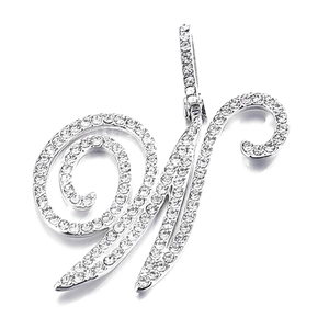 Macro shot of silver letter W pendant with iced out pave set rhinestones on white background
