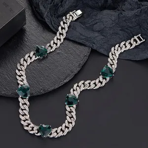 Close-up of Cuban link necklace with emerald green hearts and pavé set white zircons