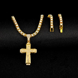 Gros plan du pendentif croix hip hop doré serti de strass brillants sur fond noir