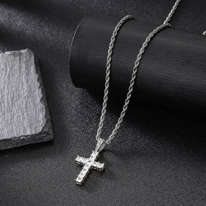 Detalle de colgante de cruz hip-hop con circonitas cuadradas en cadena de cuerda y fondo oscuro