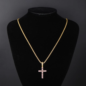 Detail of a gold-plated twist chain necklace with a pink zircon-encrusted cross pendant