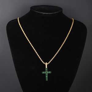 Close-up of gold rope chain necklace with green zircon pave cross pendant on black bust
