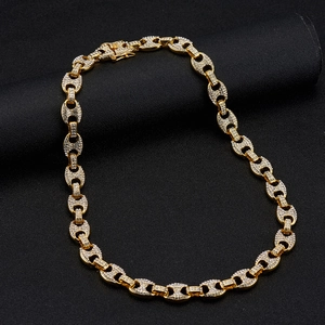 Detail of 13mm gold cuban link necklace with coffee bean links and sparkling rhinestones