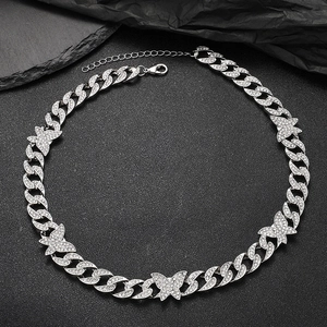 Vista dettagliata della collana a maglia cubana argento con ciondoli a farfalla scintillanti