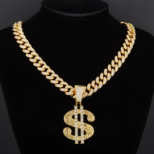 Détail du pendentif signe dollar serti de diamants sur chaîne cubaine dorée
