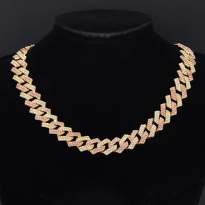 Detail of gold Cuban link necklace with iced out pink and white crystals on black bust
