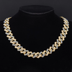 Close-up of gold Cuban link chain with inlaid blue and white zircon on a black bust