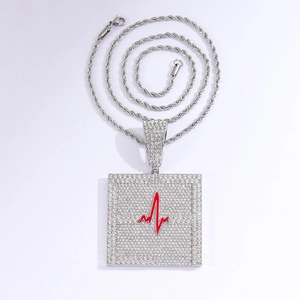 Détail du pendentif carré hip hop avec symbole EKG rouge et strass transparents