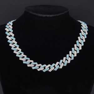 Detail shot of iced-out Cuban link chain with silver and light blue pavé zircons