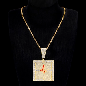 Détail du pendentif carré doré avec ligne de battement cardiaque et chaîne torsadée