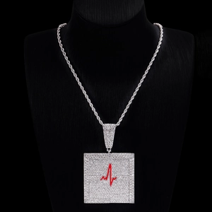 Détail du pendentif carré hip hop argenté avec ligne cardiaque rouge et cristaux