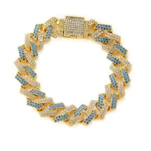 Golden Cuban link chain necklace with pave blue and white crystals on white background