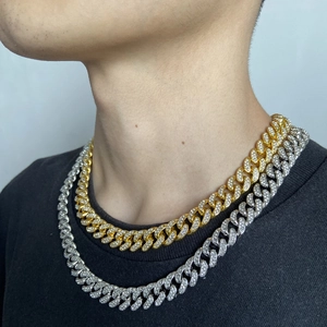 Detail of gold and silver iced out Cuban link chains with white rhinestones on neck