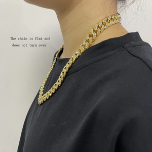 Close-up of golden rhinestone-encrusted Cuban link chain with a flat non-flip design