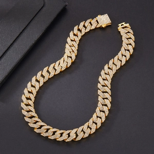 Close-up of golden Cuban link necklace with triple-row iced out rhinestones on black leather