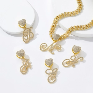 Vue détaillée des pendentifs lettres plaqués or avec boucles en cœur étincelantes