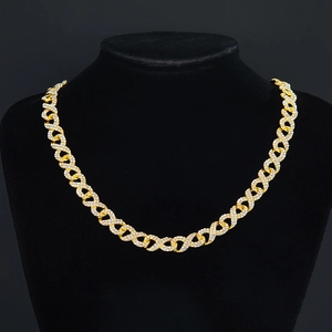Gros plan d'un collier doré à maillons infini avec cristaux pavés sur buste noir