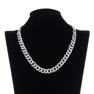 Close-up of hip hop silver Cuban link chain with pave rhinestones on a black bust stand