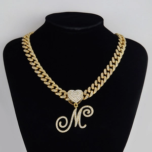 Détail du collier chaîne cubaine dorée avec pendentif cœur et lettre M pavé