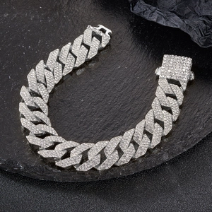 Close-up detail of iced-out silver Cuban link chain with three rows of rhinestones