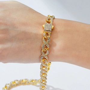 Détail d'un bracelet gourmette hip hop doré avec cristaux scintillants et fermoir à boîte