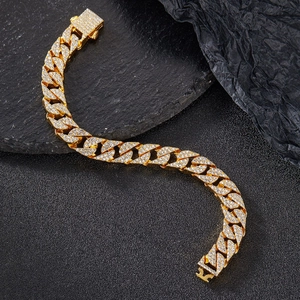 Λεπτομερής macro λήψη χρυσής αλυσίδας Cuban link με πολυτελή τετράγωνη αγκράφα και διαμάντια