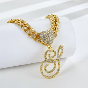 Détail du collier cubain doré avec pendentif lettre S et fermoir coeur en diamant