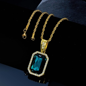 Close-up of hip hop gold rope chain with a large rectangular green gemstone pendant