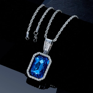 Macro shot of rectangular blue gemstone pendant with silver twist rope chain on black surface