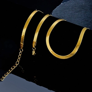 Polished golden herringbone chain bracelet with lobster clasp on black velvet display