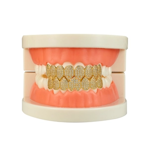Detailed view of gold hip hop grillz set with heart shape design and white cubic zirconia
