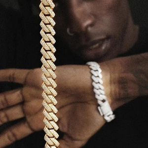 Λεπτομέρεια χρυσής αλυσίδας Cuban link με λαμπερά κρύσταλλα micro-pave σε κοντινό