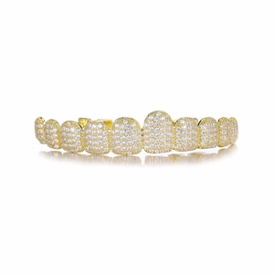 Macro detail of 14k gold plated hip-hop grillz set with sparkling paved white zircons