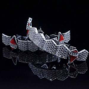 Macro shot of silver hip-hop grillz with white zircons and red details on black background