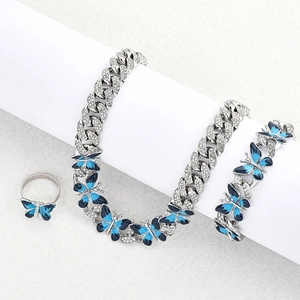 Detail view of silver hip-hop jewelry set with blue enamel butterflies and white crystals