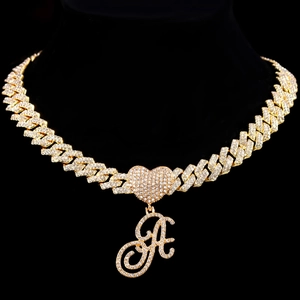 Détail du pendentif cœur glacé et de la lettre A sur une chaîne cubaine dorée