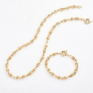 Détail du collier et bracelet à maillons de nœud dorés avec fermoir à anneau ressort
