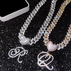 Détail de chaînes cubaines glacées or et argent avec pendentifs cœur lettres R et Q