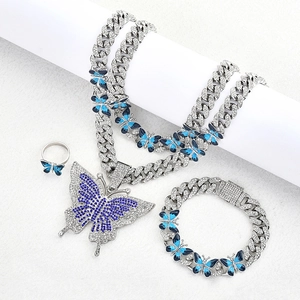 Vue détaillée d'une parure hip hop avec pendentif papillon bleu sur chaîne cubaine argent