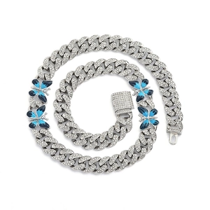 Détail de la chaîne cubaine argentée avec pendentifs papillons bleus et zircons