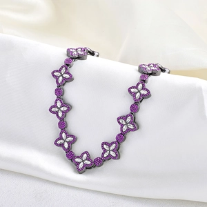 Detailed macro view of 15mm clover chain with purple and white crystals on silk