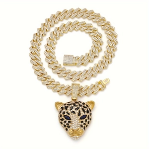 Détail de chaîne cubaine dorée avec pendentif tête de léopard serti et yeux bleus