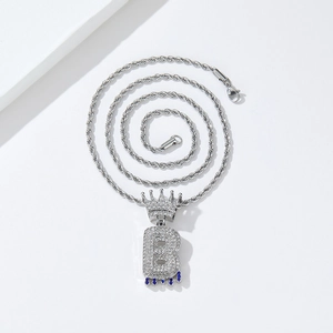 Detailed macro view of iced-out silver crown letter B pendant with deep blue gemstones