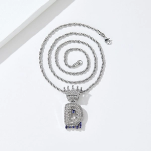 Close-up of hip hop crown letter D pendant with iced out stones and blue water drop detail