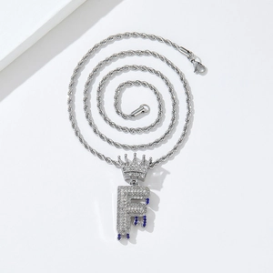 Detailed close-up of hip hop crown letter F pendant with blue dripping oil effect