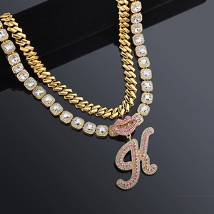 Detail of hip hop Cuban link necklace with crystal letter K and pink lip pendant