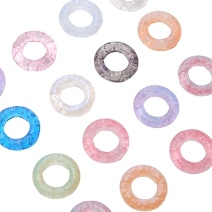 Macro shot of 25mm translucent glass rings with embossed spiral texture for DIY jewelry
