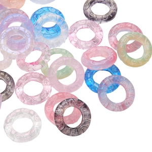 Macro detail of 25mm resin ring connectors with intricate moire scroll relief patterns
