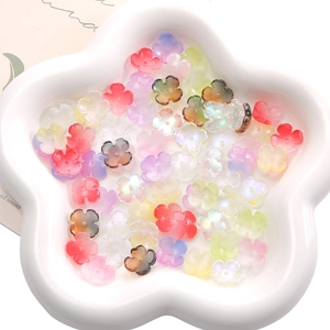 Macro view of colorful translucent five-petal flower glass beads in a star dish