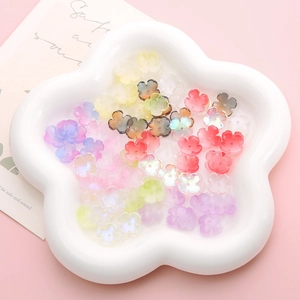 Colorful mixed glass flower beads for DIY jewelry making in a decorative ceramic petal tray
